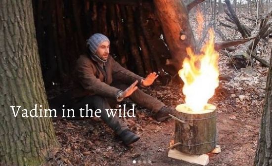 Vadim in the wild happily sitting near swedish fire torch in the forest of Ukraine.